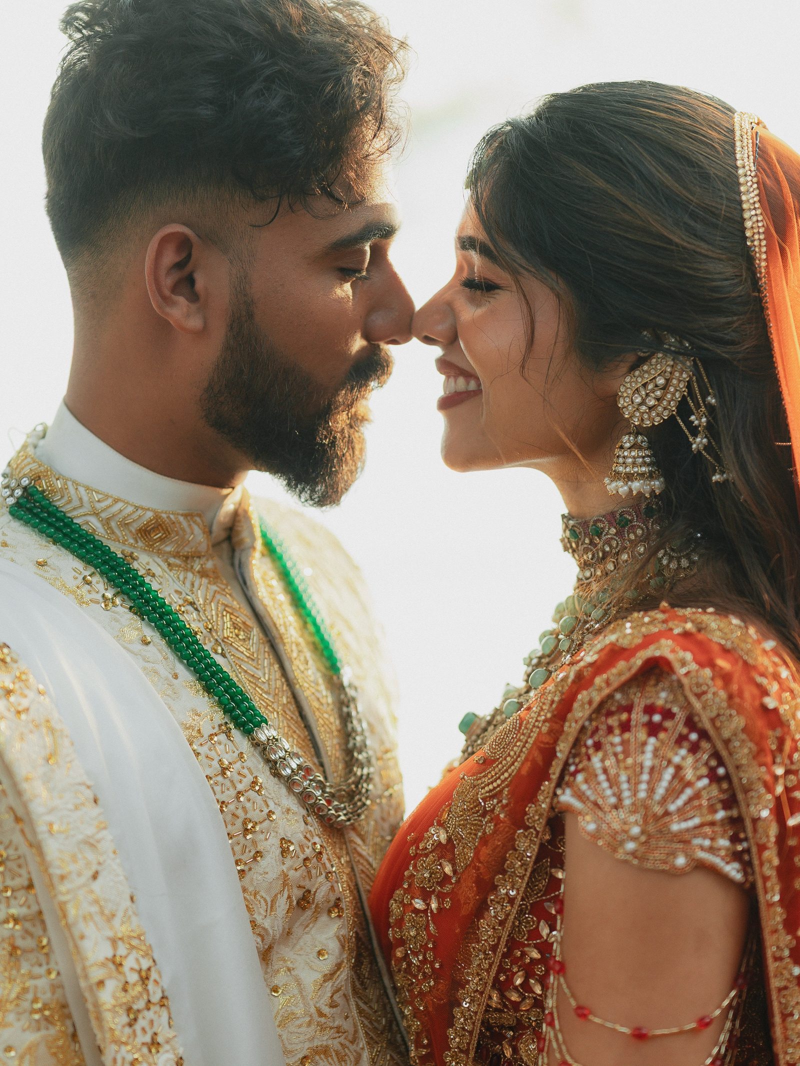 A Malayali bride wearing heirloom kundan and palakka jewellery, forehead-to-forehead with her groom