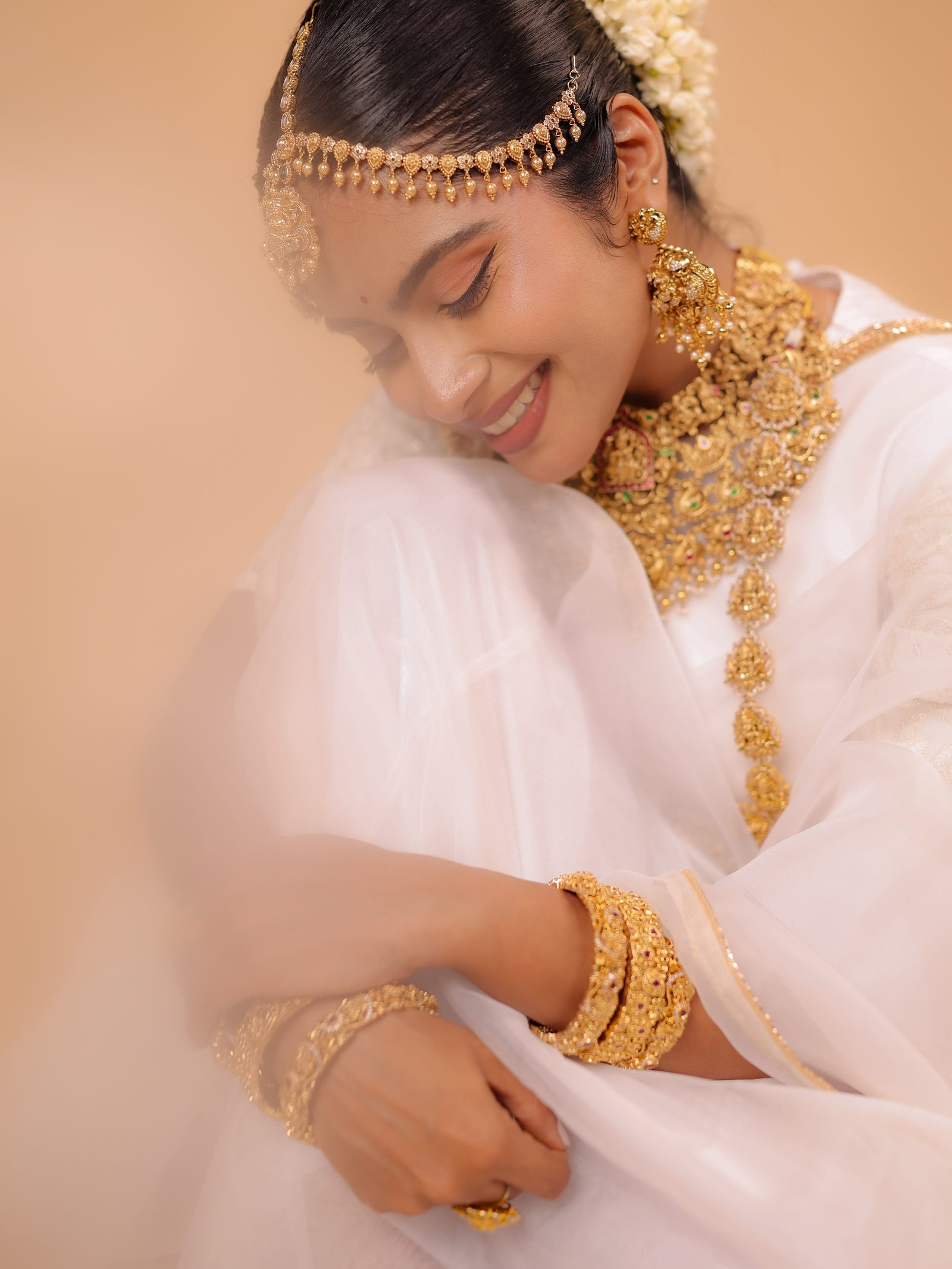 A bride at the Thrissur Golden Cup showroom in white kasavu and full gold