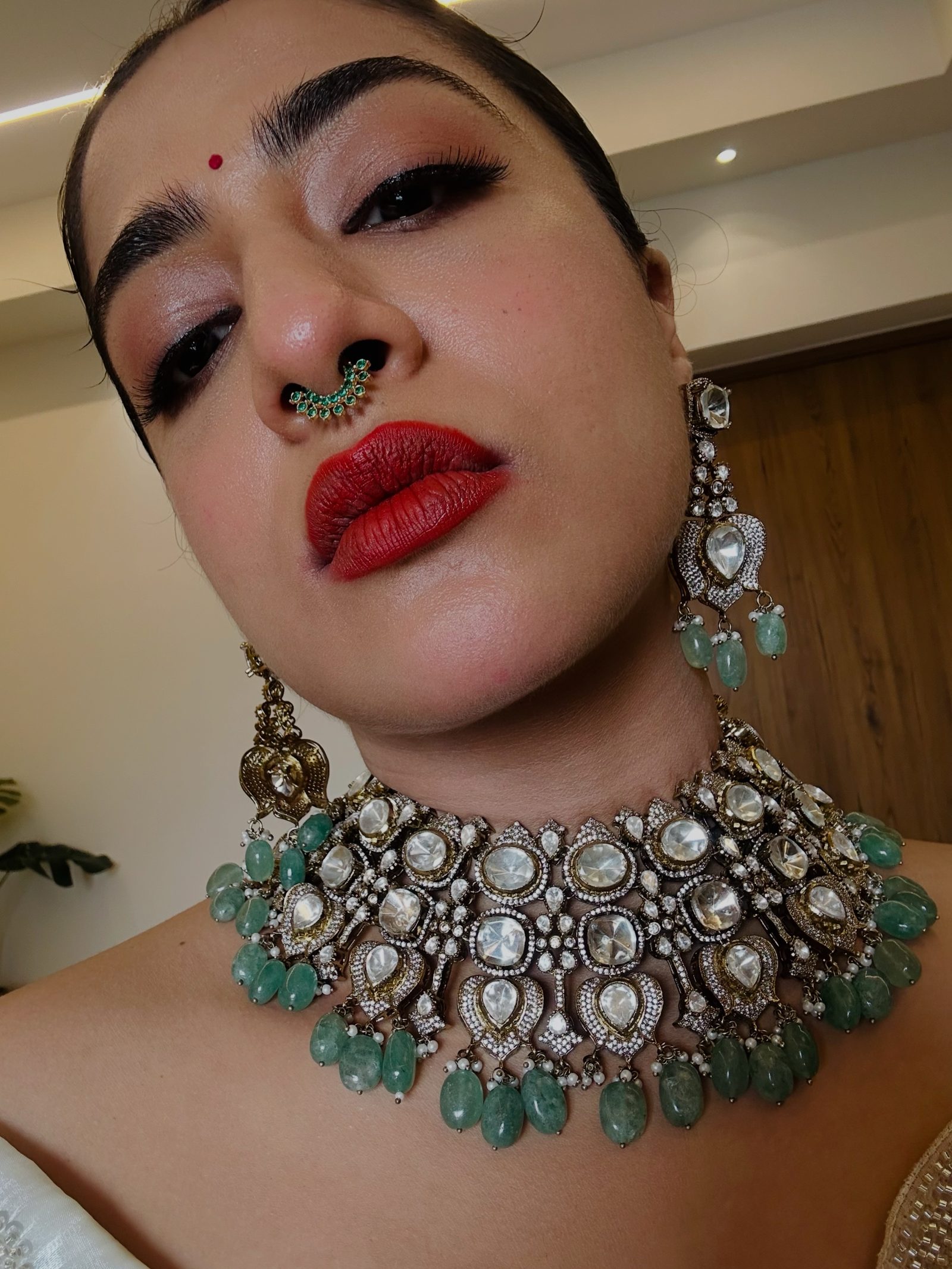 A bride wearing a premium kundan choker with green stones and uncut polki