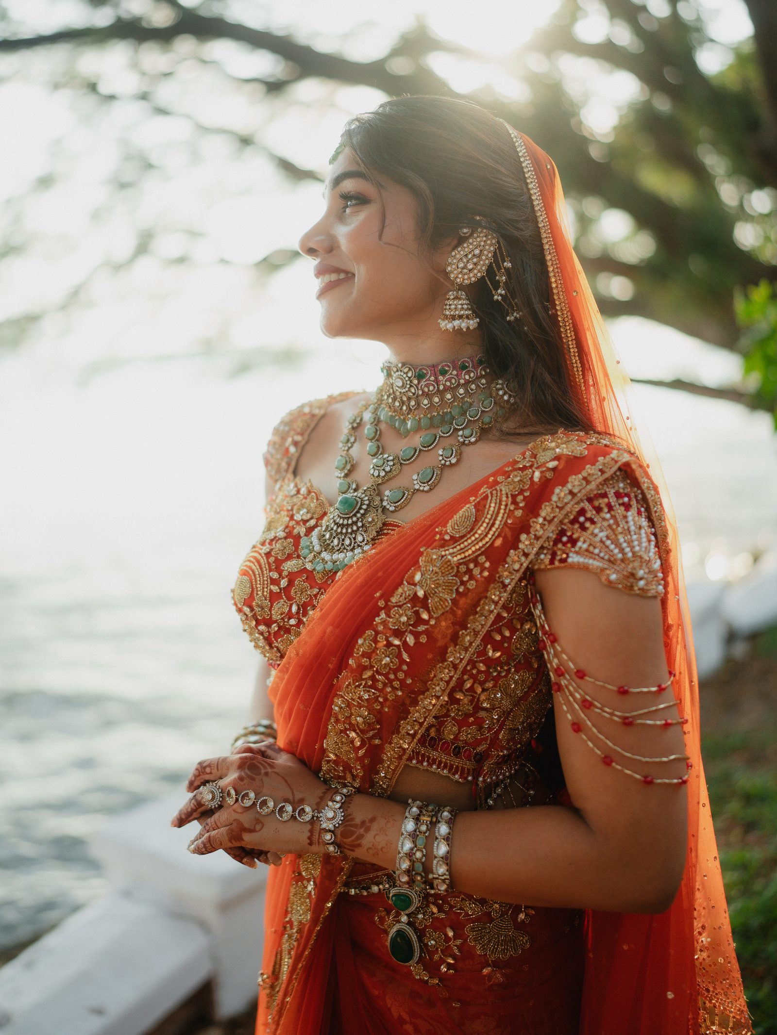 Reshma, a Muslim bride in a saffron lehenga wearing kundan and jadau kemp jewellery, photographed beside a Kerala backwater